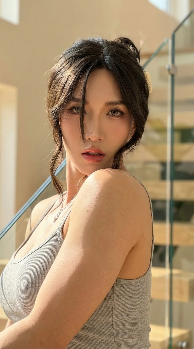 高端生活肖像:女性肩托下巴,浅灰背心,银链吊坠,玻璃栏杆背景